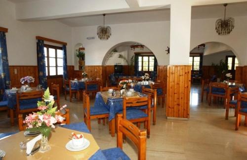 a dining room with tables and chairs in a restaurant at Panorama Hotel in Agios Stefanos