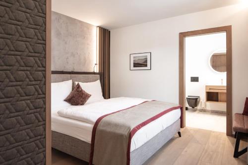 a hotel room with a bed in a room at Hotel Salzburg in Saalbach Hinterglemm