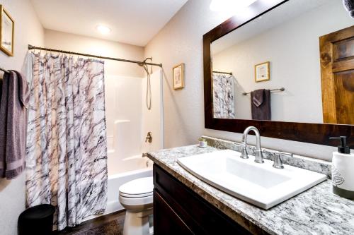 a bathroom with a sink and a toilet and a mirror at Merrifield Vacation Rental with Dock and River Access in Merrifield