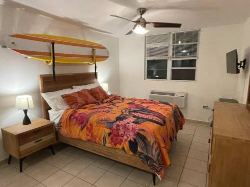 a bedroom with a bed with a surfboard on it at Lovely 2 bedroom condo with pool and beach access in Rincon