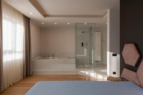 a bathroom with a shower and a bed in a room at Sauna&Jacuzzi Apartment in Cluj-Napoca