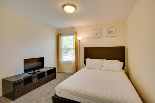 um quarto com uma cama e uma televisão de ecrã plano em Family-Friendly Lansing Home with Covered Balcony! em Lansing