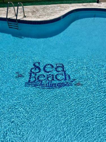 a sign in the water in a swimming pool at Lovely 2 bedroom condo with pool and beach access in Rincon
