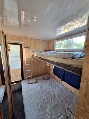 a small room with two bunk beds and a window at Szalupa H9 in Zakroczym