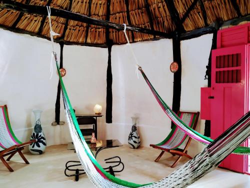 a room with two chairs and a hammock at Hotel y Museo Aldea Maya Toktli Orígenes - Suite La Casa Maya - Alberca, Wifi Starlink, Tour Museo in Izamal