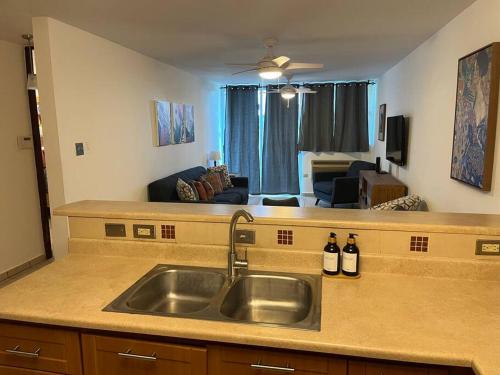 a kitchen with a sink and a living room at Lovely 2 bedroom condo with pool and beach access in Rincon