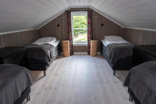 2 camas en una habitación pequeña con ventana en Furetoppen Panorama, en Stryn
