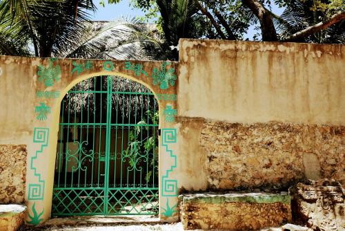 an entrance to a building with a green gate at Hotel y Museo Aldea Maya Toktli Orígenes - Suite La Casa Maya - Alberca, Wifi Starlink, Tour Museo in Izamal