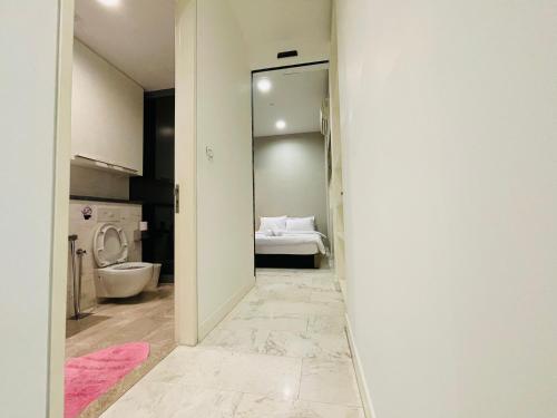 pasillo que conduce a un baño con aseo en The Platinum Suites KLCC By World Luxury, en Kuala Lumpur