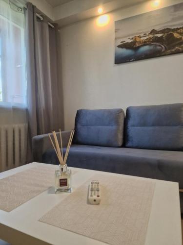 a living room with a table and a blue couch at Butas 34 in Šiauliai