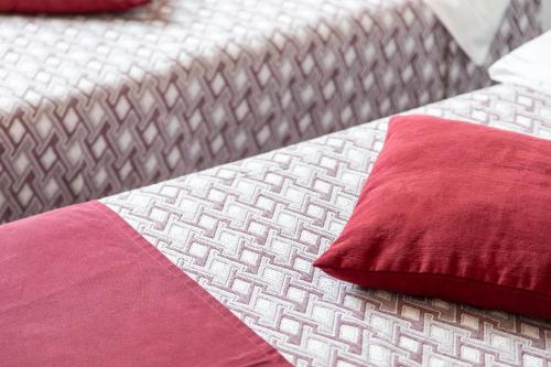 two beds with red pillows on top of each other at La Locanda d'Oro in Monastir