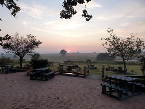 a group of picnic tables in a field at sunset at 4 Seasons Country Club in Erasmus