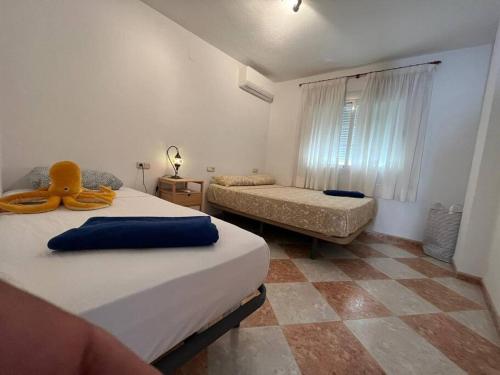 a bedroom with two beds and a couch and a window at Casa De Noor in Órgiva