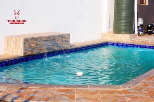 a swimming pool with a water fountain at Tshukudu Guesthouse in Soweto