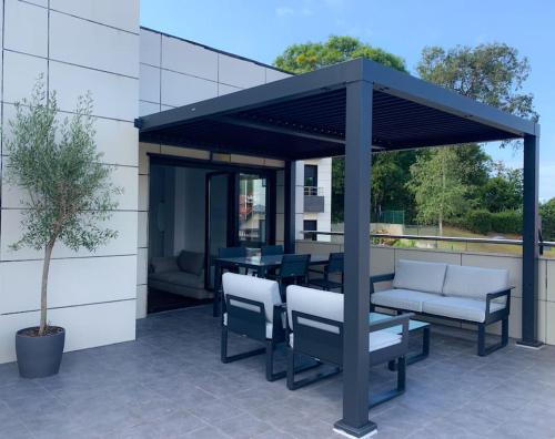 un gazebo con sedie e un tavolo su un patio di Atico con espléndida terraza a Comillas