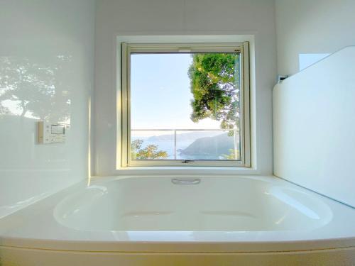 a bath tub in a room with a window at White House Atami in Atami