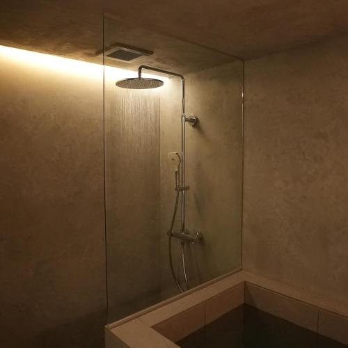 a shower stall with a glass door with a light at White House Atami in Atami