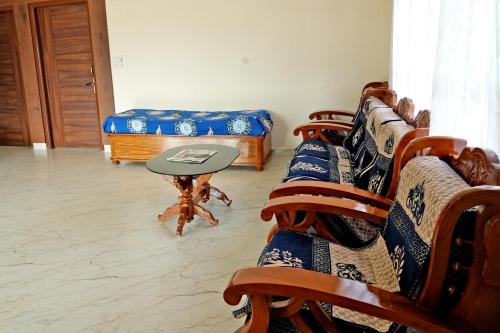 a room with a couch and a table and chairs at Chimneys Homestay - Full House, Near to Falls & Trek in Sakleshpur