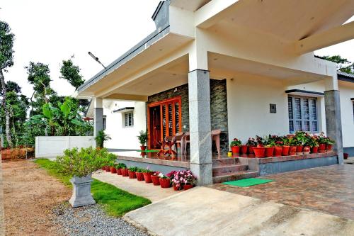 a house with a red door and some plants at Chimneys Homestay - Full House, Near to Falls & Trek in Sakleshpur