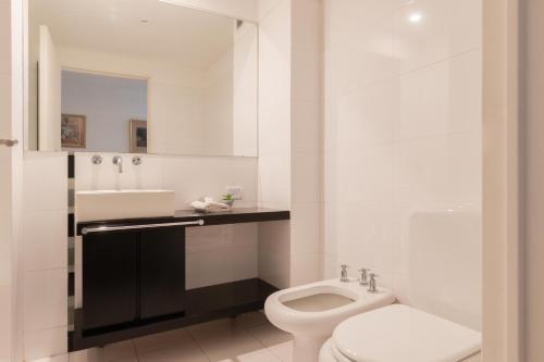 Baño blanco con aseo y lavamanos en Fliphaus Nicaragua 6000 - 2 Bd Live Hotel en Buenos Aires