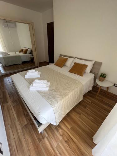a large white bed in a room with a mirror at Welcome Home Quartu Sant'Elena in Quartu SantʼElena