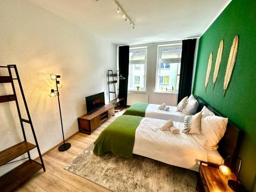 - une chambre avec un lit et un mur vert dans l'établissement Das Berg Apartment Rüttenscheid, Netflix, nahe Messe, Klinikum, à Essen