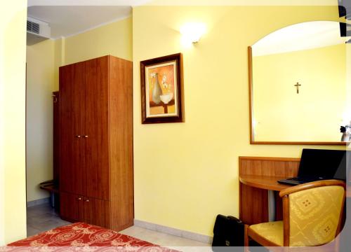 a room with a desk and a mirror and a chair at Hotel e Appartamenti La Solaria con parcheggio gratuito a soli 450 MT dalla nuova Basilica di Padre Pio in San Giovanni Rotondo