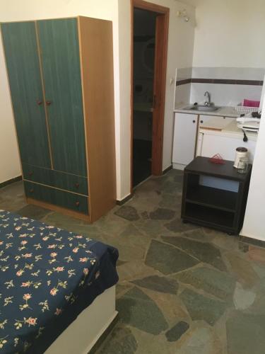um pequeno quarto com uma cama e uma cozinha em Youth Ηostel Archipelagos - semi basement studio at Possidonia em Ano Syros