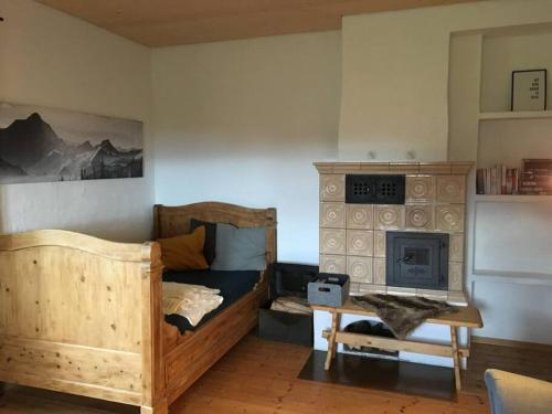 a bedroom with a wooden bed and a fireplace at KampenZeit Ferienwohnung-traumhafter Panoramablick in Aschau im Chiemgau