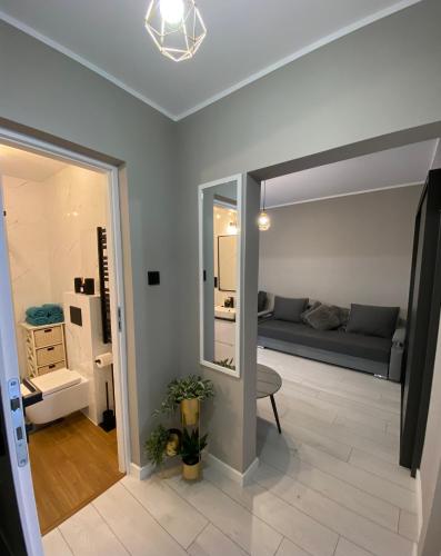 a living room with a couch and a mirror at Apartament Jarosław in Jarosław
