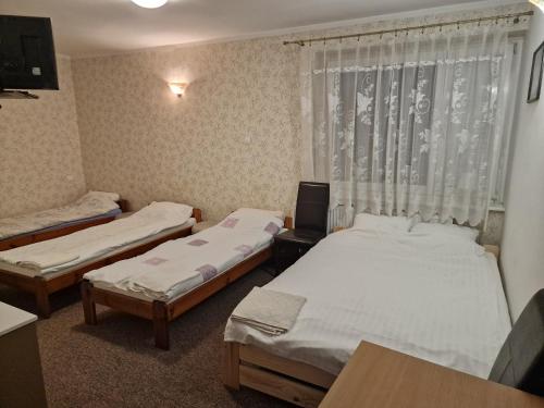 een kamer met 2 bedden en een raam bij Agroturystyka Gramburg in Zblewo