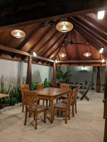 una mesa de madera y sillas en un pabellón en Araam Inn, en Nellaidhoo