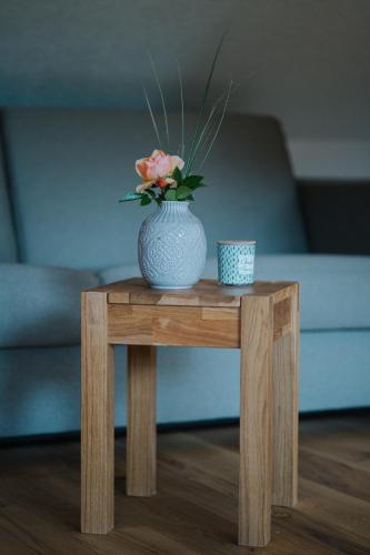a blue vase with a flower on a wooden table at Nockventure Ferienhaus Gnesau in Gnesau