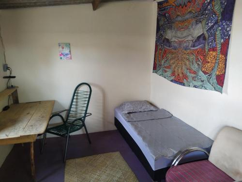 a room with a bed and a chair and a tapestry at Casa Aloe Vera in Cavalcante