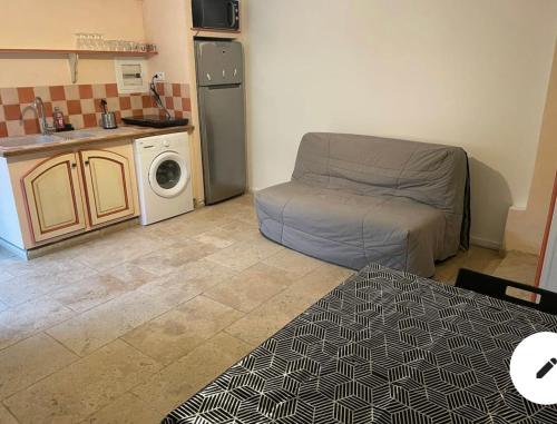 sala de estar con sofá y lavadora en Studio 2 personnes avec Terrasse, en Marsella