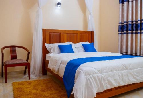 1 dormitorio con 1 cama grande y 1 silla en 5 Bedroom Villa Near Pride Inn, en Mombasa