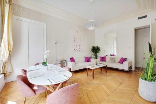 - un salon avec une table et des chaises roses dans l'établissement Charmant appartement - 2BR 4P - Champs-Élysées, à Paris