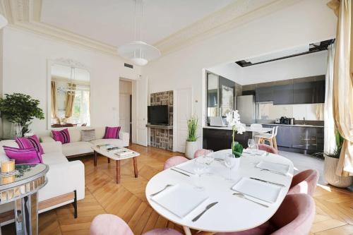 - un salon avec une table blanche et des chaises roses dans l'établissement Charmant appartement - 2BR 4P - Champs-Élysées, à Paris