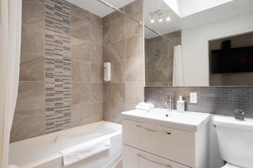 y baño con lavabo, bañera y aseo. en MtlVacationRentals - MTL ZOO, en Montreal