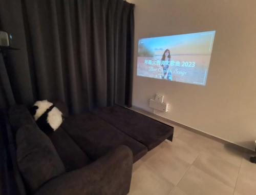 a living room with a couch and a tv at Super Comfort 2R2B Luxury Seaview Sandakan in Sandakan
