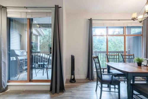 a dining room with a table and chairs and a window at Updated Townhouse in Village. Pool/Hot Tub/Parking in Whistler