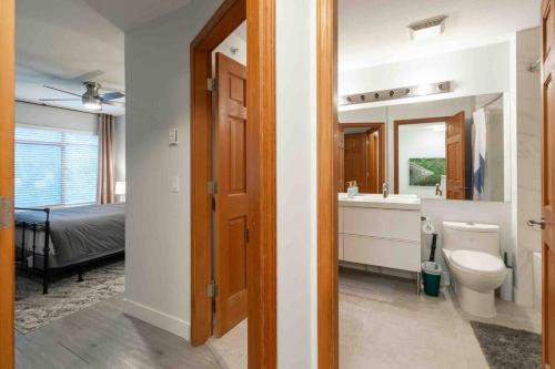 a bathroom with a toilet and a sink and a bed at Updated Townhouse in Village. Pool/Hot Tub/Parking in Whistler
