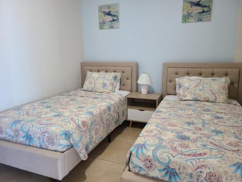 two beds sitting next to each other in a bedroom at Fantastic Beach condo with pool and mountain views in Nueva Gorgona