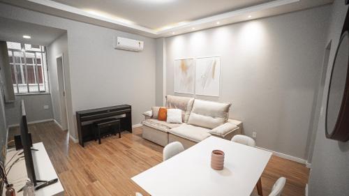 a living room with a couch and a piano at Apartamento no bairro do Flamengo. Reformado e aconchegante! in Rio de Janeiro