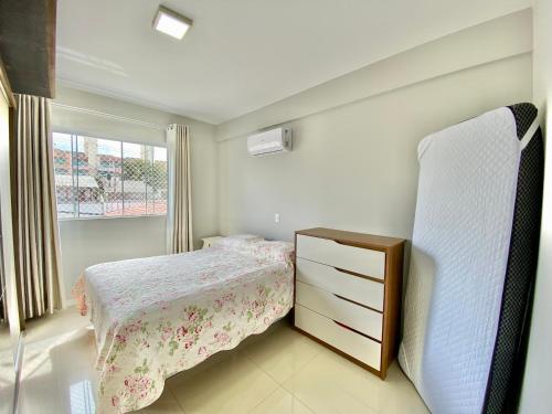 1 dormitorio con 1 cama, vestidor y ventana en Edíficio Varadero, en Bombinhas