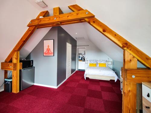 Zimmer im Dachgeschoss mit einem Bett und einer Treppe in der Unterkunft Studio Les Grandes Menières in Le Donjon