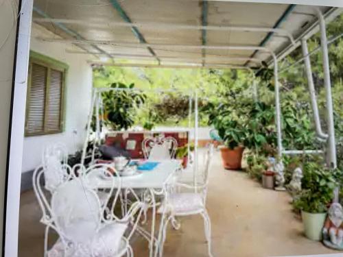 un patio con mesa, sillas y plantas en Casa Patrizia, en Villapiana