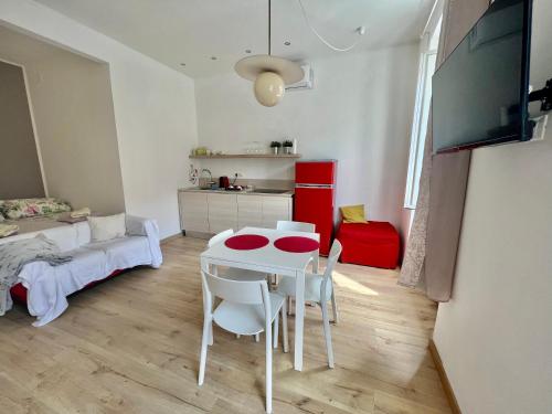 a room with a table and chairs and a bedroom at Alla Scalinata del Teatro Rossetti confort suites parcheggio in Trieste