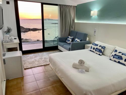 a hotel room with a bed and a view of the ocean at Hotel Delfin Azul in A Lanzada