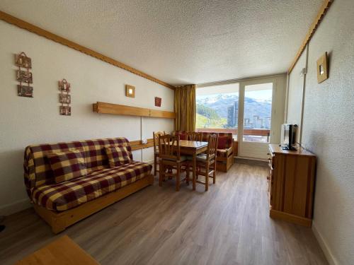 un salon avec un canapé, une table et des chaises dans l'établissement Studio 4 pers - Sud - Balcon - 3 Vallées - FR-1-452-13, aux Menuires